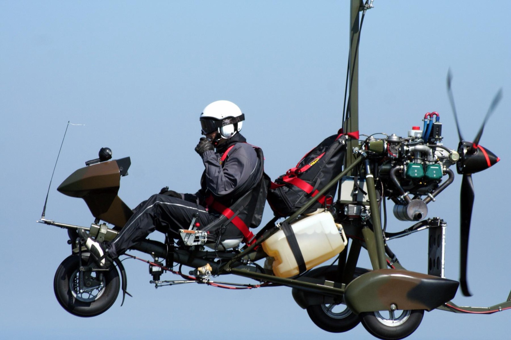 An open-frame homebuilt gyrocopter in flight, the kind whose era built the old reputation.