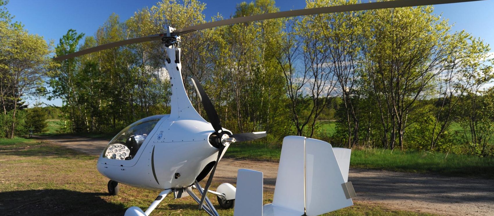 A white gyrocopter parked with rotor at rest, the kind of machine an annual inspection covers.